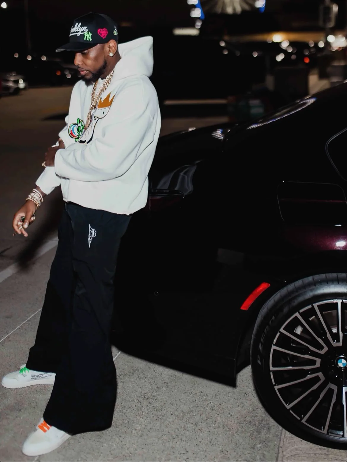 Fabolous wearing PSRVE beside a black car at night